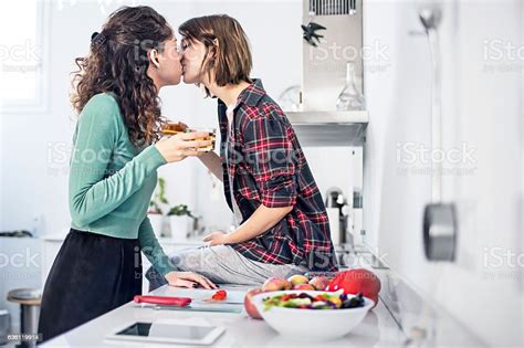 Pareja De Lesbianas Románticas Besándose En La Cocina Foto De Stock Y