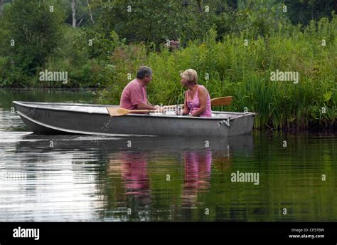 An Adult Couple In A Rowboat On A Lake Or Pond Stock Photo Alamy