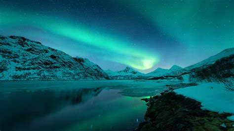 Beautiful Colorful Aurora Borealis Mountains With Snow Under Starry Sky