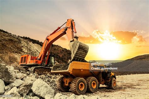 Excavator Loading Dumper Truck On Mining Site High Res Stock Photo