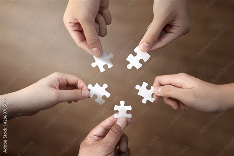 Hand Of Diverse People Holding Jigsaw Connecting Together Jigsaws