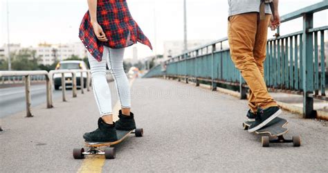 Young Attractive Couple Riding Skateboards And Having Fun Stock Photo