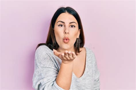 Young Hispanic Woman Wearing Casual Clothes Looking At The Camera Blowing A Kiss With Hand On