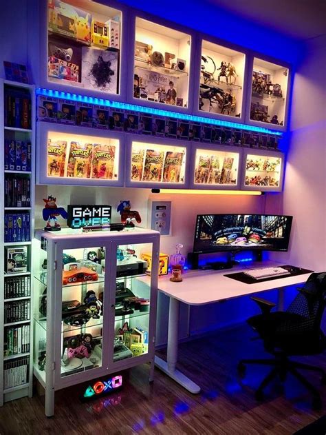 A Gaming Room With Two Computers And Games On The Shelves Above It Is