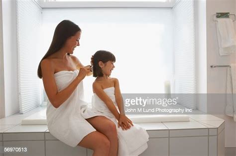 Mother And Daughter Wrapped In Towels Brushing Hair Photo Getty Images