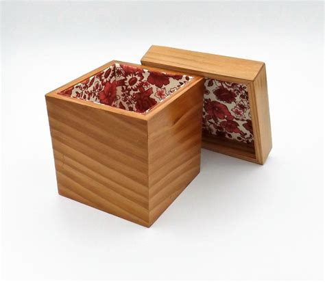 an open wooden box with red and white fabric inside