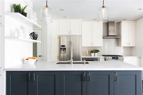 Maybe you would like to learn more about one of these? White kitchen with navy blue island. A pair of clear glass ...