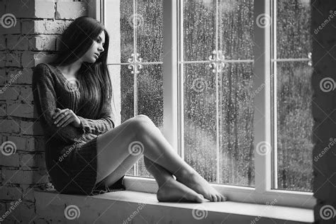 Beautiful Young Woman Sitting Alone Close To Window With Rain Drops
