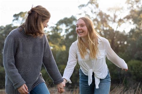 Image Of Two Teenage Girls Holding Hands In Natural Setting Austockphoto
