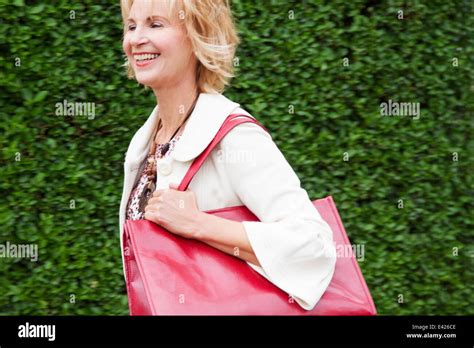 Mature Woman Walking Briskly With Red Shoulder Bag Stock Photo Alamy