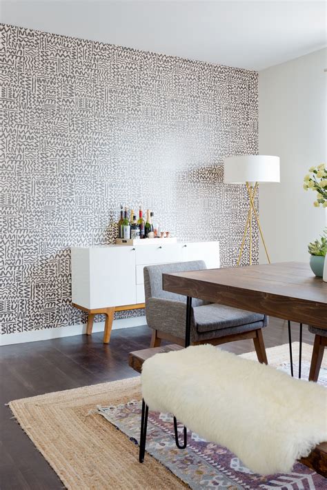 A Dining Room With A Wallpaper Accent Wall And Layered Rugs Accent