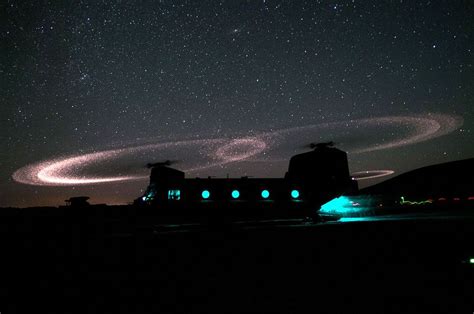 Dust On The Blades Of A Chinook Helicopter Lights Up The Night In The