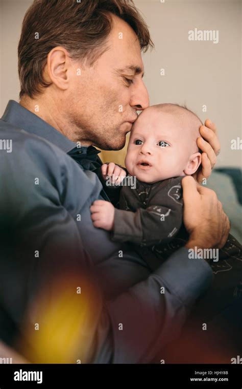 Father Kissing His Newborn Baby At Home Stock Photo Alamy