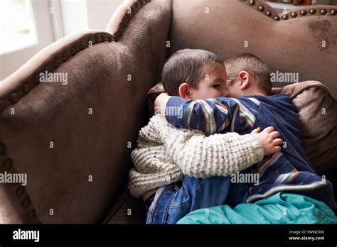 Two Young Brothers Cuddling On Armchair Together Stock Photo Alamy