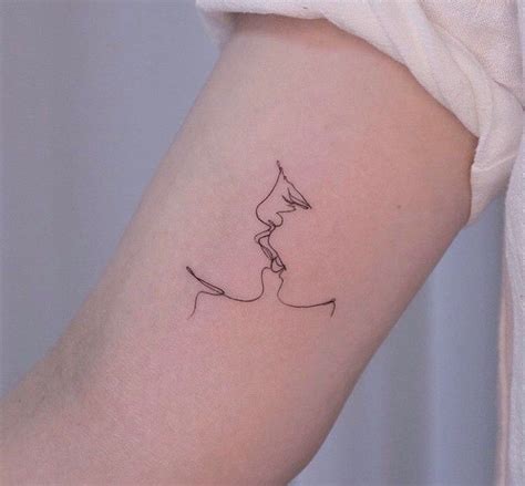 A Womans Arm With A Line Drawing Of A Kissing Couple On The Left Side