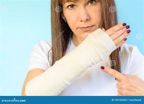 Woman With Broken Arm Bone In Cast Plastered Hand On Blue Background