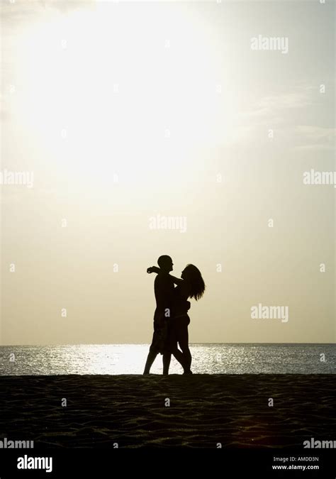 El Hombre Y La Mujer Abrazando Al Atardecer En La Playa Fotografía De Stock Alamy
