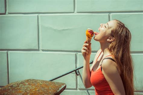 Premium Photo Woman Licking Ice Cream By Wall