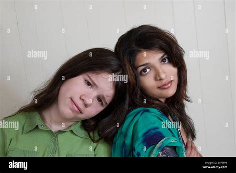 Young Indian Woman And Her Preteen Caucasian Stepsister Posing Together Model Released Stock