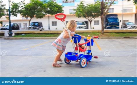 Little Blond Girl Pushes Pram Tricycle About Play Ground Stock Video Video Of Open Caucasian