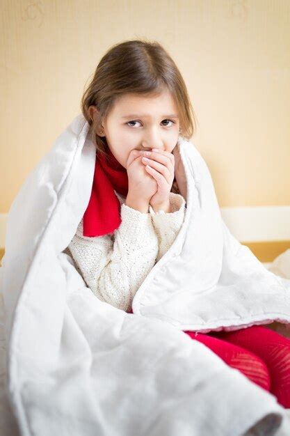 Premium Photo Portrait Of Sick Little Girl Coughing On Bed Under Blanket