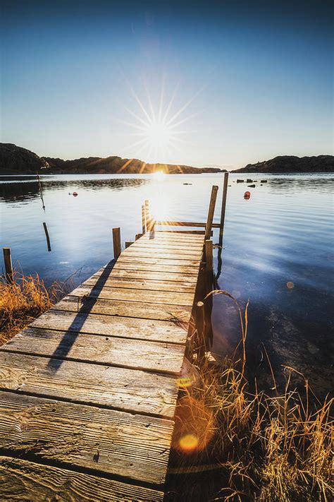 sunburst over old pier photograph by nicklas gustafsson