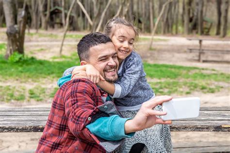 Dad And His Little Daughter Take Funny Selfies In Nature Stock Photo
