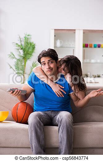 Man Watching Basketball With His Wife Canstock