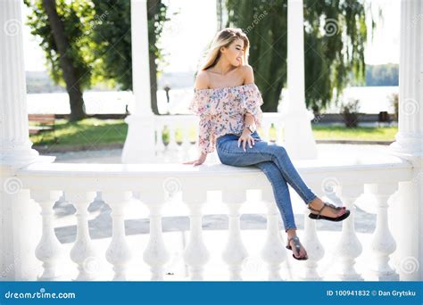 Beautiful Young Brunette Woman Sitting On Handrail In Park Stock Photo