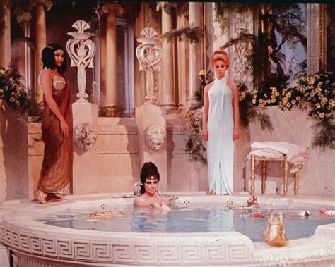 Actor Elizabeth Taylor Takes A Bath In A Tub With Two Unidentified Women Behind Her In A Still