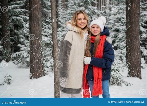 Beautiful Blonde Mom In A Fur Coat And Her Teenage Daughter Pose For A