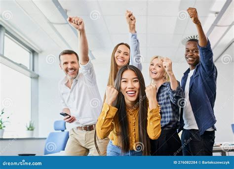 Diverse Group Of Colleagues Cheering Together In Office Stock Photo