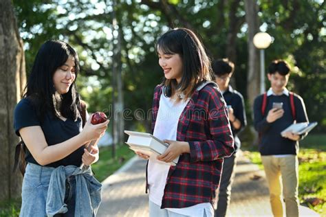 Happy University Students Going To College Class Talking While Walking