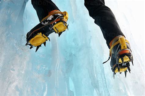 Cropped View Of Ice Climbers Feet Wearing Crampons Stock Photo