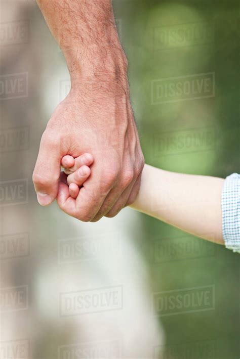 Father Holding Childs Hand Stock Photo Dissolve