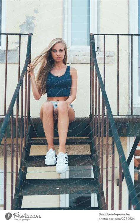 Young Fit Beautiful Blonde Woman Sitting On The Stairs Posing A