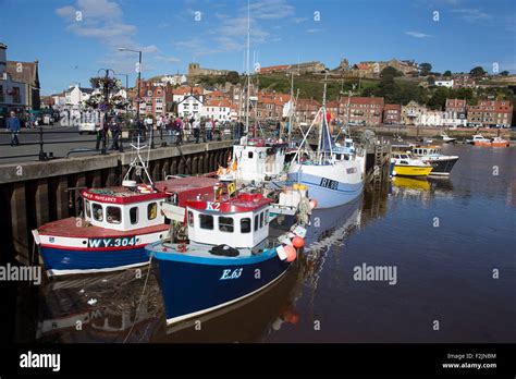 Fishing Boats Moored At The Quayside In The Harbour In Whitby A