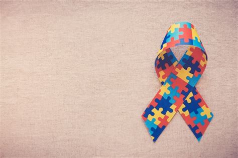 Premium Photo Hands Holding Puzzle Ribbon For Autism Awareness
