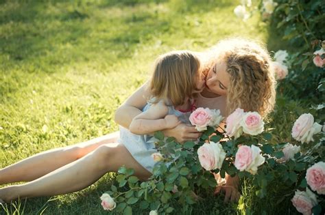 Premium Photo Mom Kissing Babe On Green Grass On Sunny Summer Day