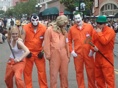 A Group Of People In Orange Jumpsuits And Masks