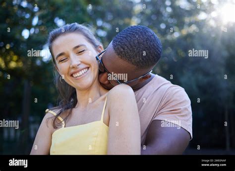 love park and kissing with an interracial couple bonding outdoor together on a romantic date in