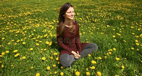 Beautiful Young Woman Relaxing On A Meadow With Many Dandelions In The