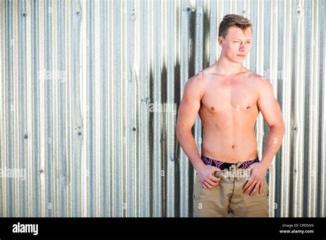 eine 19 jährige teenager junge mann person nackten oberkörper stand vor glänzenden wellpappe