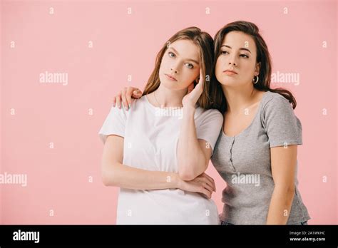 Attractive Woman Hugging Her Sad Friend Isolated On Pink Stock Photo