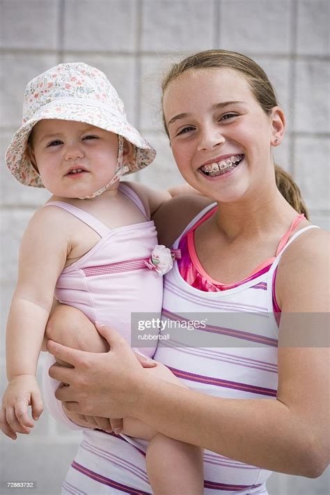 Girl Holding Baby High Res Stock Photo Getty Images