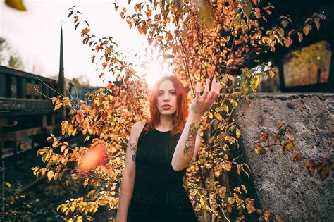 Ginger Woman Posing With A Yellow Bush Behind At Sunset By Thais Varela