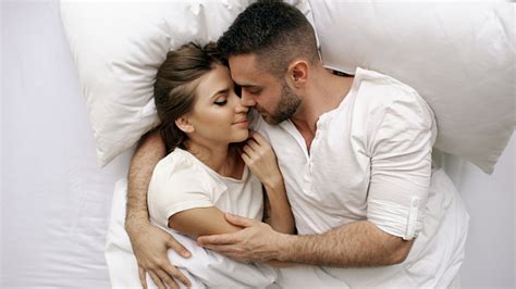 photo libre de droit de jeune couple beau et aimant baise et câlin dans le lit tout en