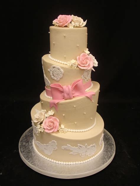 A Three Tiered Cake With Pink And White Flowers