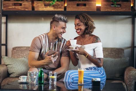 Mixed Race Couple Having Fun At The Coffee Shop Using Stock Photo