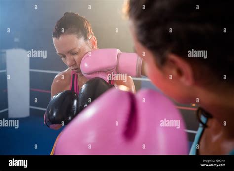 Close Up Of Female Boxer Punching Athlete In Boxing Ring Stock Photo